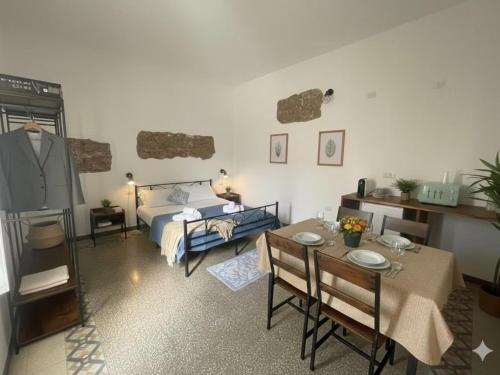 een woonkamer met een bed, een tafel en stoelen bij Luxar Suites and Apartments in Assemini