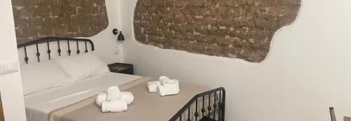 een slaapkamer met een bed met handdoeken erop bij Luxar Suites and Apartments in Assemini