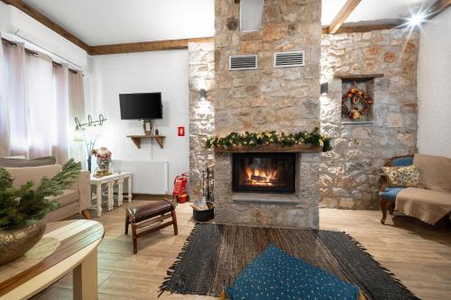 un soggiorno con camino in pietra di Villa Dianne Apt 1 Livadi Arachovas ad Aráchova