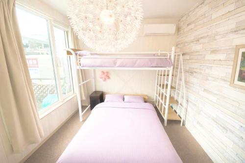 een kleine slaapkamer met een stapelbed en een kroonluchter bij Yume House in Furano