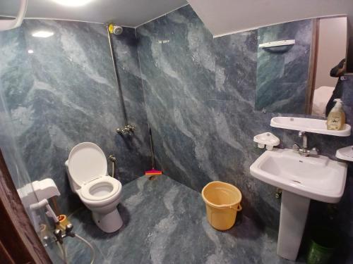 a bathroom with a toilet and a sink at Prime Star Hotel in Karachi