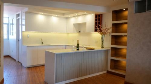 a white kitchen with a sink and a counter at Hotel Killasumaq in Cajamarca