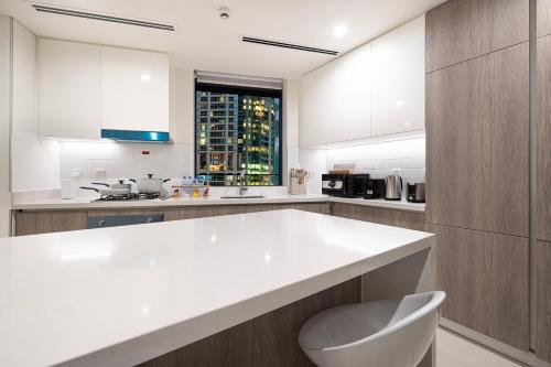 a white kitchen with a large white counter top at Marina High-Floor Premium Luxury Stay at LIV Marina for up to 9 Guests with Marina Views and Exceptional Amenities in Dubai