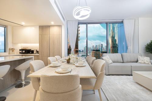 a kitchen and living room with a table and chairs at Marina High-Floor Premium Luxury Stay at LIV Marina for up to 9 Guests with Marina Views and Exceptional Amenities in Dubai
