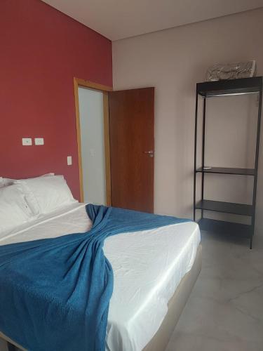 a bedroom with a bed with a blue blanket on it at Casa com 3 suítes em Juquehy in São Sebastião