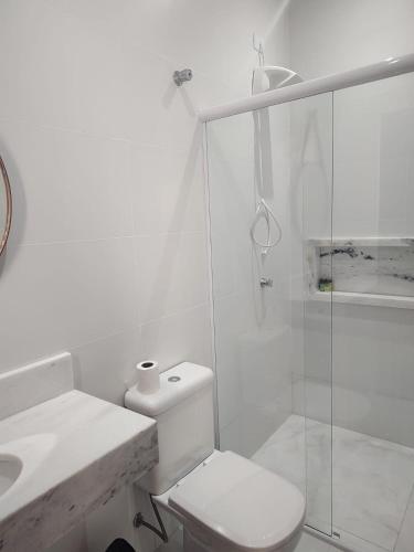 a white bathroom with a toilet and a shower at Casa com 3 suítes em Juquehy in São Sebastião