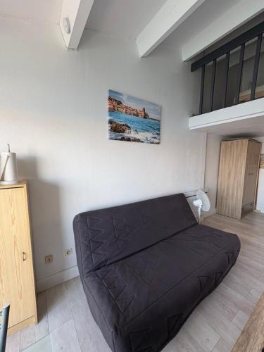 ein Schlafzimmer mit einem schwarzen Bett in einem Zimmer in der Unterkunft Marinelle in Saint Cyprien Plage