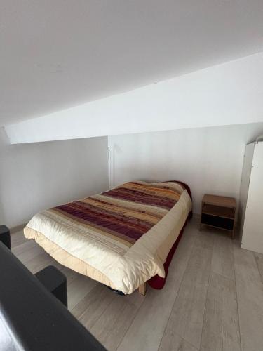 ein Schlafzimmer mit einem Bett in einem Zimmer in der Unterkunft Marinelle in Saint Cyprien Plage