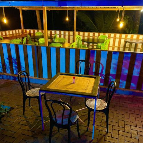 a wooden table and chairs on a patio at Nellar Dream Resort in Meppādi