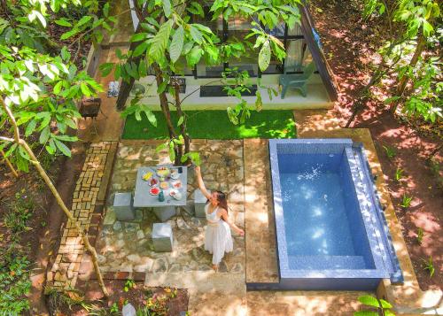 vue aérienne d'une femme debout à côté d'une piscine dans l'établissement Kandy Little White House Cabanas, à Kandy