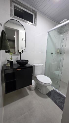 a bathroom with a toilet and a sink and a shower at Casa completa, lindamente decorada, nova com 2 quartos in São Gabriel