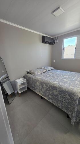 a small bedroom with a bed and a window at Casa completa, lindamente decorada, nova com 2 quartos in São Gabriel