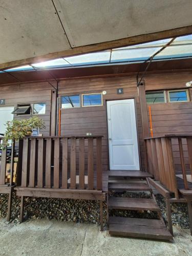 een houten bank voor een huis bij Ironhause in Pucón