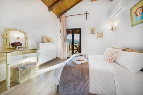 una camera da letto bianca con un letto e uno specchio di Villa Dianne Apt 2 Livadi Arachovas ad Aráchova