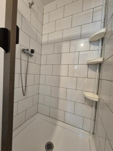 een badkamer met een douche en witte betegelde muren bij Ironhause in Pucón