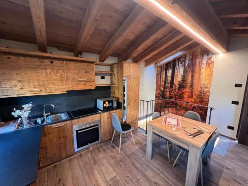 een keuken en eetkamer met een tafel en stoelen bij La Boschera in Champoluc