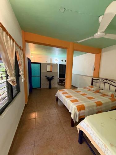 a bedroom with two beds and a bathroom at La Casita De Marlen in Puerto Ángel