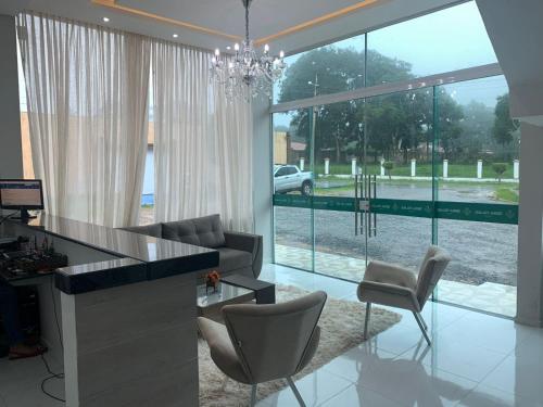 een woonkamer met een bureau en stoelen en een groot raam bij Serra Village Hotel in Ubajara