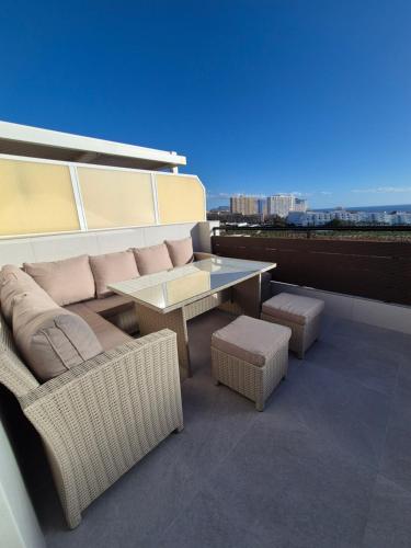 a balcony with a couch and a table and chairs at Paraiso View Duplex Penthouse in Callao Salvaje