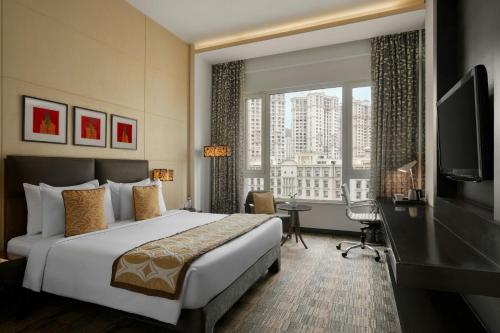 um quarto de hotel com uma cama, uma escrivaninha e uma janela em Meluha The Fern Mumbai, Powai, Series by Marriott em Mumbai