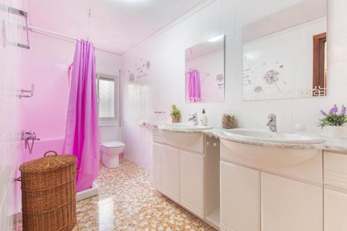 ein rosafarbenes Bad mit einem Waschbecken und einem WC in der Unterkunft La Herreria de Esteban in Cuevas Labradas