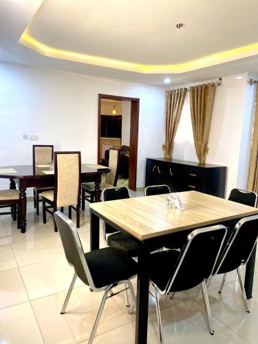 a dining room with wooden tables and chairs at Adonai Guesthouse in Agbara