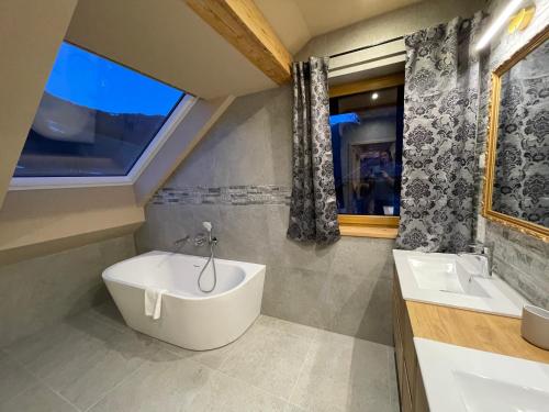 a bathroom with a tub and a sink at Nockalm Cottage in Bad Kleinkirchheim