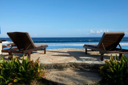two chairs sitting on a patio near the ocean at Jasri Bay Hideaway in Jasri