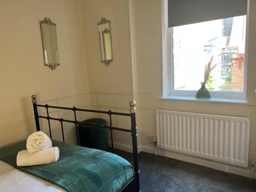 een slaapkamer met een bed met handdoeken erop bij Tyneside Two Bedroom Apart in Gateshead