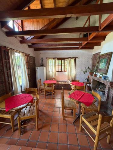 ein Wohnzimmer mit Tischen und Stühlen sowie eine Küche in der Unterkunft El Amanecer in Mina Clavero