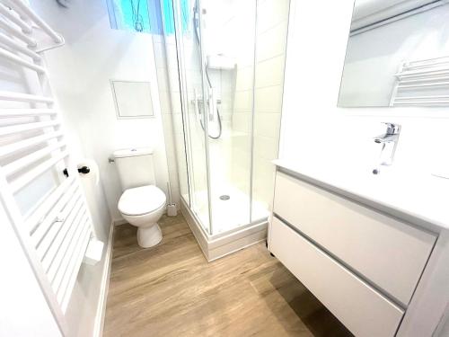 a white bathroom with a toilet and a shower at Studio cosy refait à neuf - Parking privé in Lanester