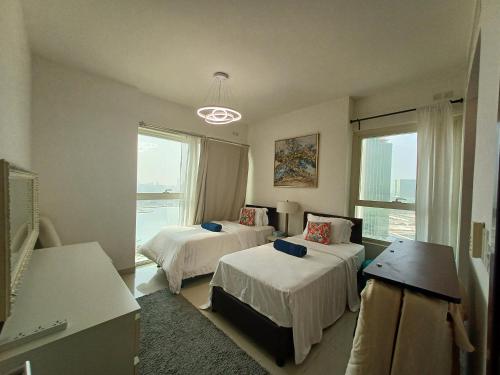een hotelkamer met twee bedden en een raam bij Exclusive Sea-View 2BR Apartment with Fireworks View in New-year eve in Abu Dhabi