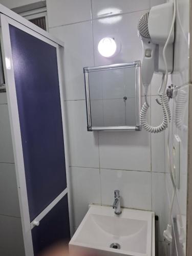 a bathroom with a sink and a phone on the wall at Studio Lapa in Rio de Janeiro