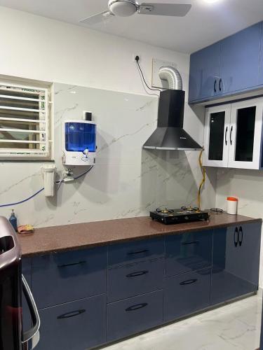 a kitchen with blue cabinets and a counter top at Next Nest in Gannavaram
