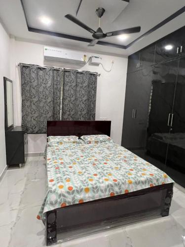a bed in a room with a ceiling fan at Next Nest in Gannavaram
