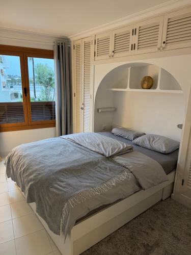 a large bed in a bedroom with a window at Apartment AlcudiaMar in Alcudia