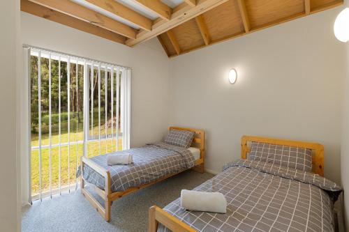 a bedroom with two beds and a window at Settle @ Sawmill in Mount Buller