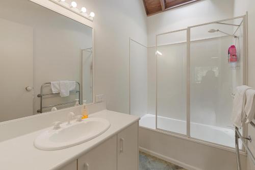a white bathroom with a sink and a shower at Settle @ Sawmill in Mount Buller
