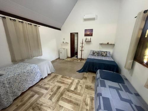 een slaapkamer met twee bedden en een houten vloer bij Chalé Mirante do Lago Cotijuba in Belém