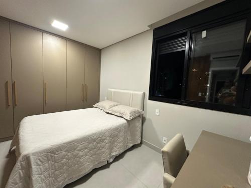 een kleine slaapkamer met een bed en een raam bij Apartamento moderno no Horto in Ipatinga