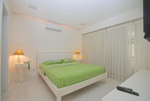 Un dormitorio blanco con una cama verde y una ventana en Ipanema Apart-hotel on the Beach, en Río de Janeiro