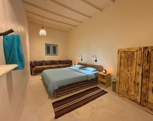 a bedroom with a bed and a wooden cabinet at Siwa Oracle Hostel in Siwa