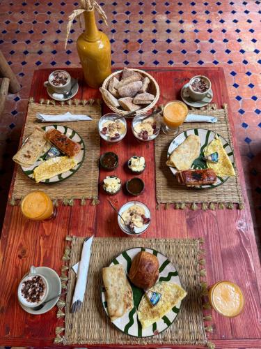 a table with plates of food on top at hostel riad maqam in Essaouira