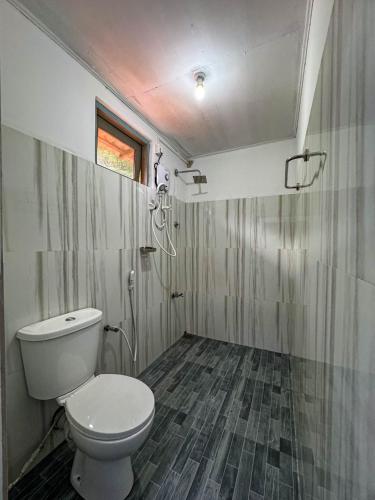 a small bathroom with a toilet and a shower at Dee Ella hotel in Danowita