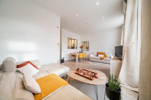 een woonkamer met een witte bank en een tafel bij Hyper centre Cannes - 2 pièces avec balcon - 4 couchages in Cannes