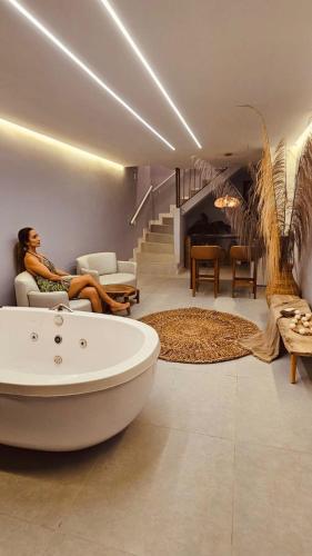 a woman sitting on a couch in a living room at Mahalo Exclusive Boutique in Maragogi