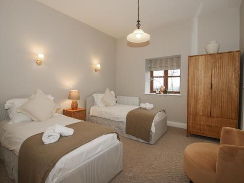 ein Hotelzimmer mit zwei Betten und einem Stuhl in der Unterkunft The Park in Craven Arms