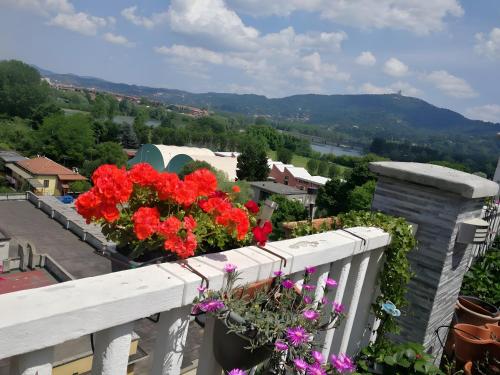 un balcone con fiori rossi su una ringhiera bianca di Casa Sofìa a Torino