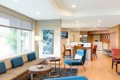 a living room with a couch and tables and chairs at TownePlace Suites by Marriott Toledo Perrysburg in Perrysburg