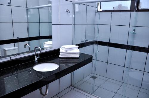 a bathroom with a sink and a mirror at Oft Neve's hotel in Goiânia